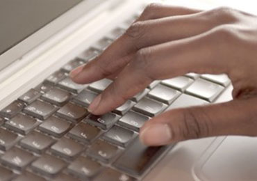 closeup of hands on a computer keyboard